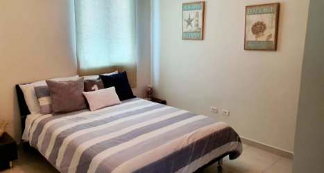 Bedroom with striped bedding contemporary decor PH Rodman Bijao Panama beachfront condo