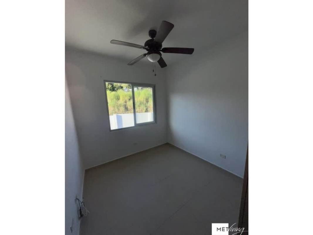 Minimalist bedroom with tile floor, built-in wardrobe and ceiling fan in Altos del Crisol Villa Lucre Panama City
