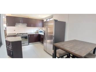 Kitchen with granite countertops and wood cabinetry in PH Woodlands house Panama Pacifico