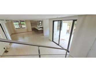 Elegant master bedroom featuring balcony, walk-in closet, and garden views at PH Nativa Panama