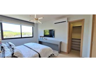 Large modern bedroom with scenic views, eco-friendly design, neutral palette IMATERRA Panama Pacifico