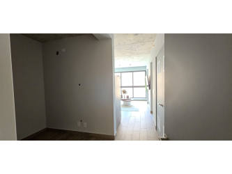 Open-concept living room with large window and balcony access in Centriqo Panama Pacifico apartment