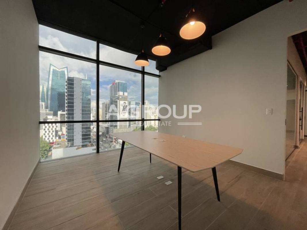 Open workspace with glass walls, wood tile flooring, and skyline view in Tower Financial Center