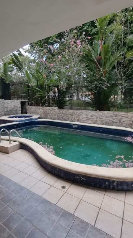 Curved swimming pool with spa surrounded by tropical landscaping and patio in luxury Albrook Clayton residence Panama