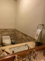 Bathroom interior with tile walls, built-in sink, large mirror in Buenaventura Panama luxury condo
