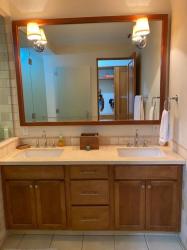 Bathroom with double wood vanity sinks, large mirror, glass shower at Paseo de la Casa Buenaventura Panama