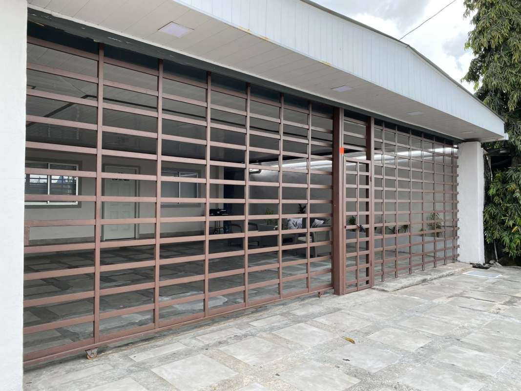 Covered patio with gray wicker seating set in Urbanización Don Bosco furnished house