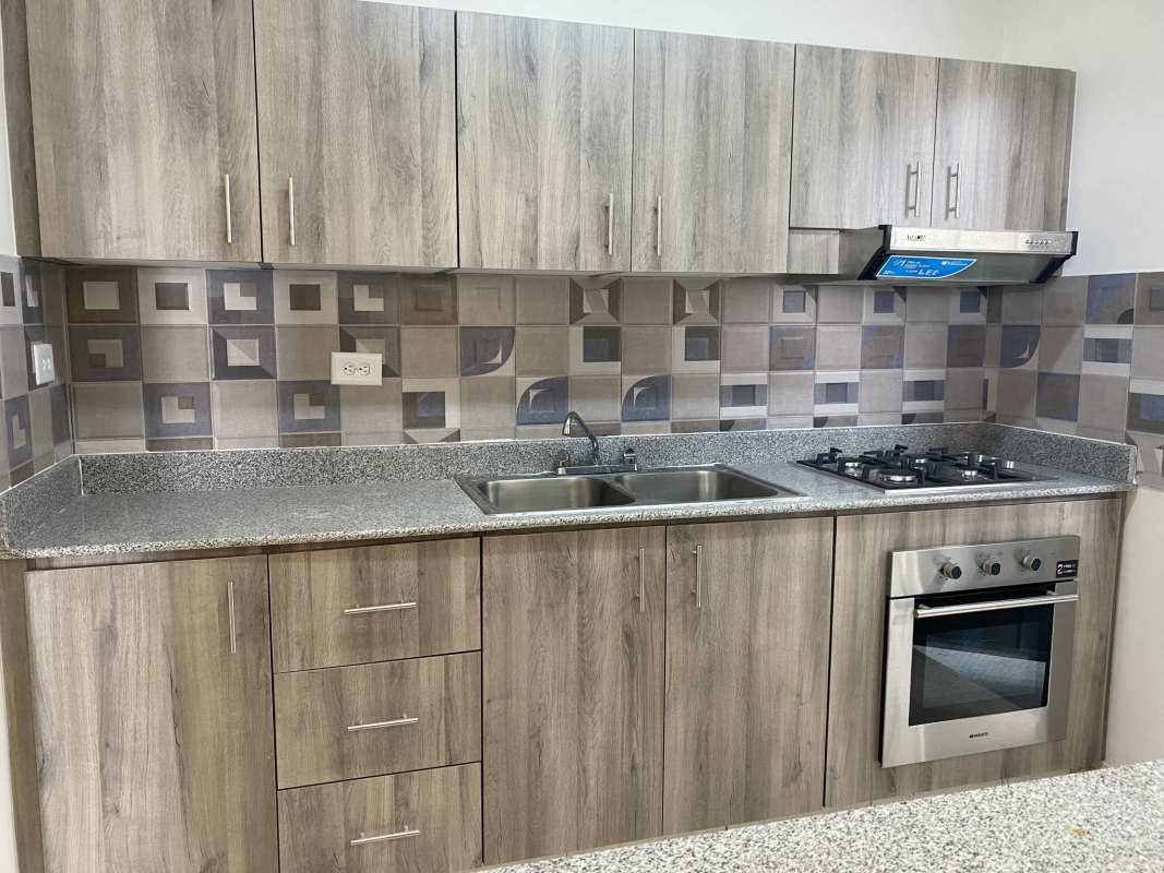 Modern kitchen with granite counters and built-in oven in furnished house Don Bosco