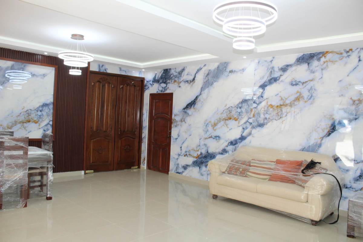 Living room with marble walls, cream sofa covered, and LED lighting in Villa Zaita house