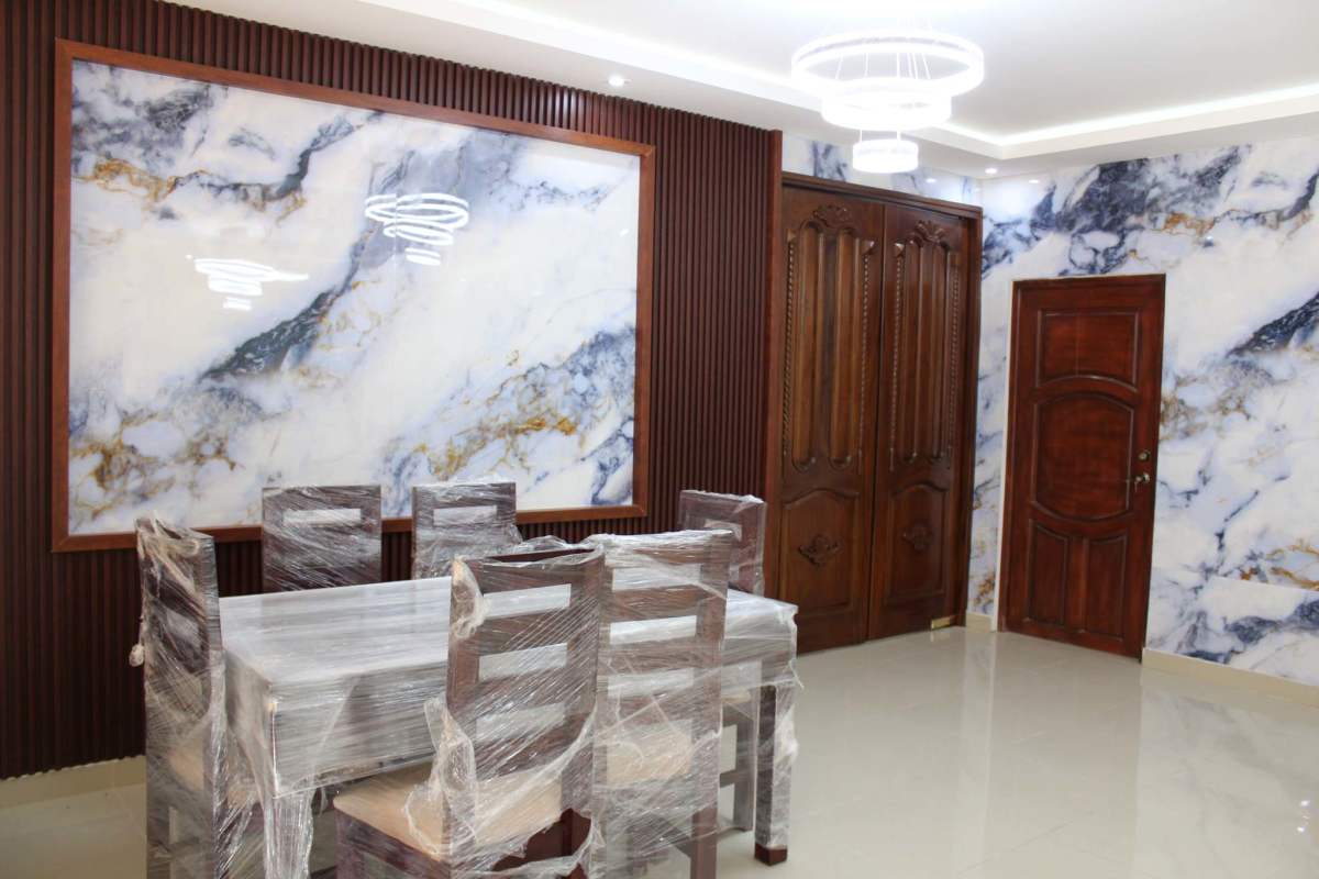 Dining room with marble accent wall and wood doors in Villa Zaita Panama house