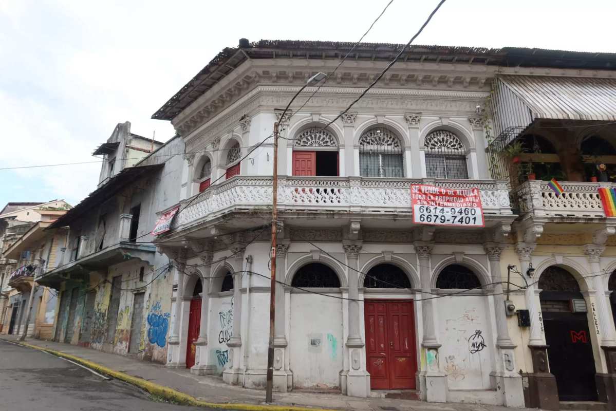 Two-story colonial-style building with ornate balcony railings, red doors and historic charm in Casco Viejo Panama