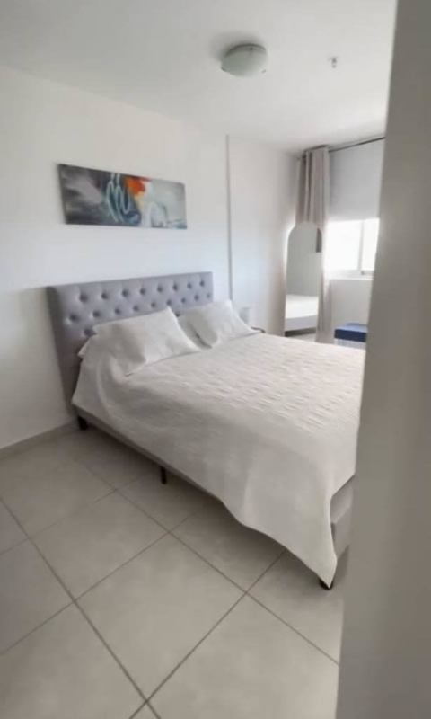 Modern bedroom with large window and city skyline views at PH Bay View Panama City