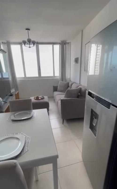 Dining space by large window with ocean view inside Bay View Tower apartment Panama City