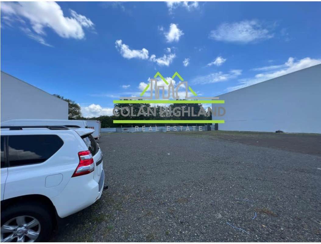 Commercial development zone with modern corporate buildings beside empty construction lot