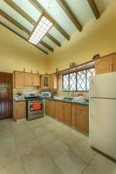 Mediterranean-style living room with wooden beams, bright natural light, ocean glimpses in Farallon beach house