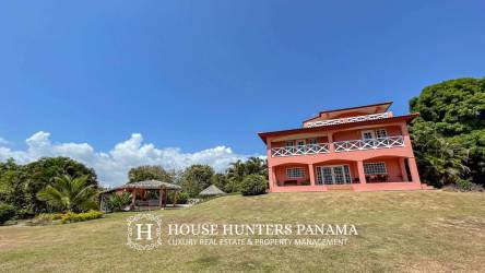 Two-story colonial home with balcony and lush gardens on beachfront estate in Chumico Panama