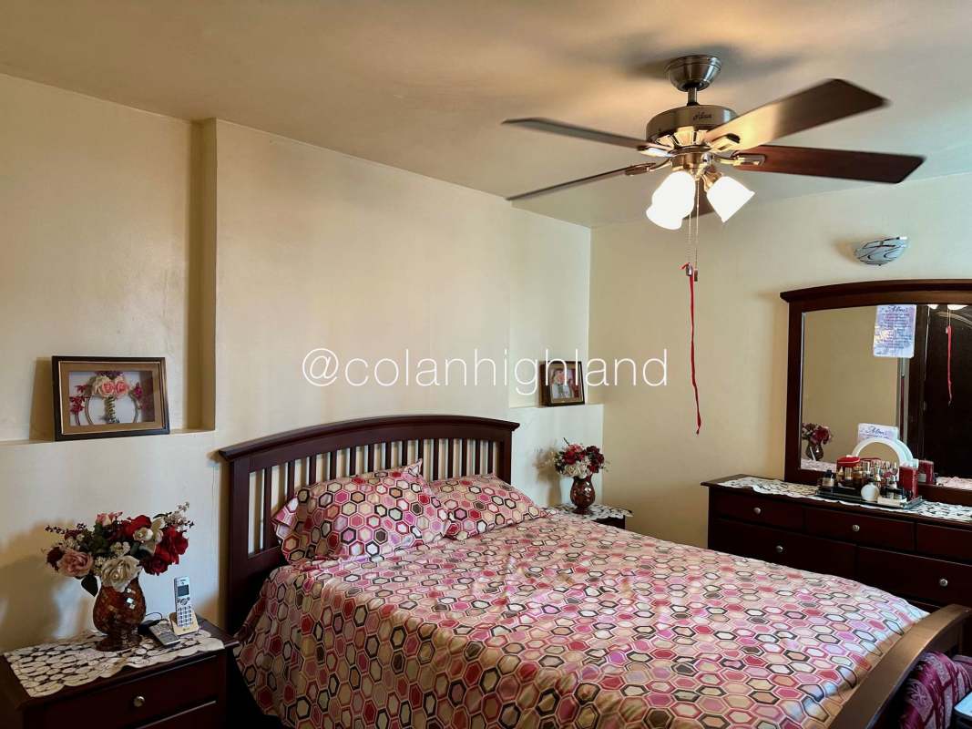 Traditional kitchen with ample wooden cabinetry, double sink, floral tile backsplash, and appliances in Pacific Wind apartment Panama