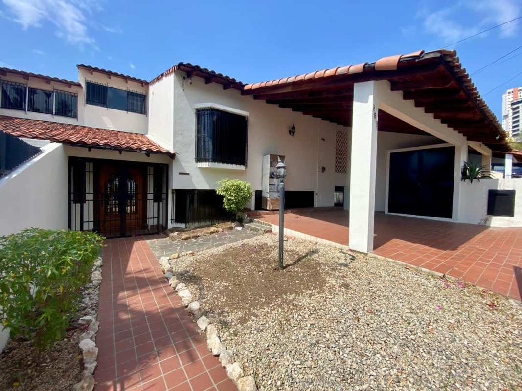 Elegant staircase with wood railings and chandelier in duplex home Dos Mares Panama City