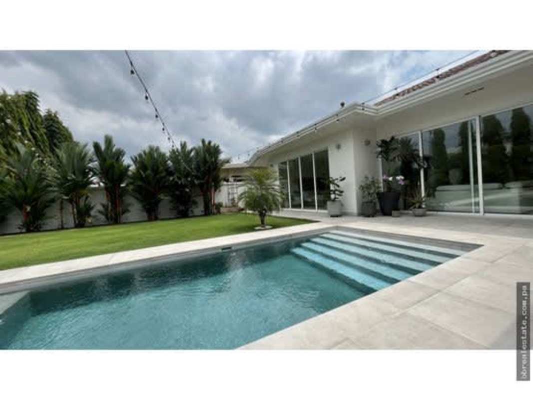 Modern backyard with swimming pool, green lawn, privacy wall, perfect for entertaining in Costa Sur Panama