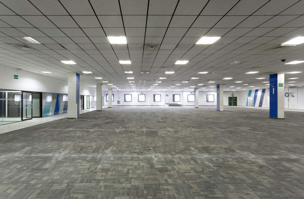 Spacious commercial open plan office with drop ceiling lighting tiles in Chanis Via Cincuentenario