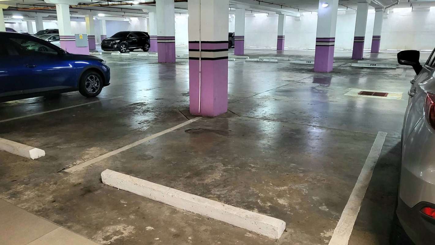 Modern three-level commercial complex with mirrored glass walls and large parking lot at Terrazas de Albrook Panama