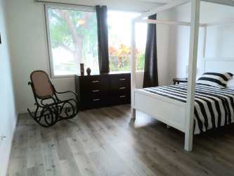 Master bedroom with four poster bed, wood floors and garden views Coronado Golf Panama