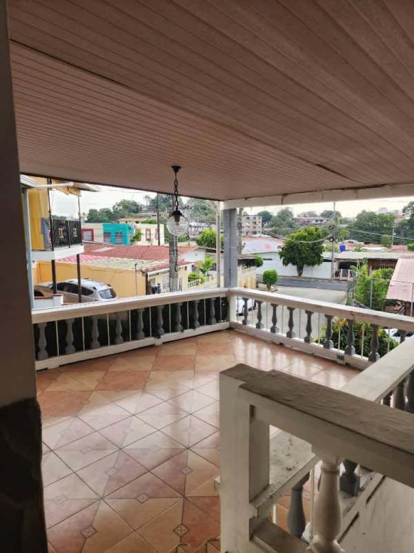 Covered tiled terrace with balustrade overlooking quiet street in Los Harinos Hato Pintado