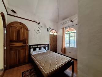 Bright bedroom with closet and arched window in Penonomé rustic house