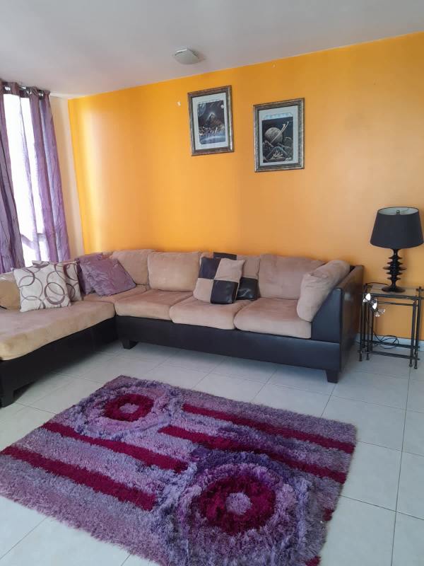 Modern living room with sectional sofa bright orange wall PH Plaza Edison Panama