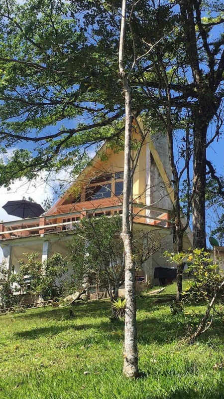 Covered patio area with terracotta floors, outdoor dining and green view Cerro Azul mountain house Panama