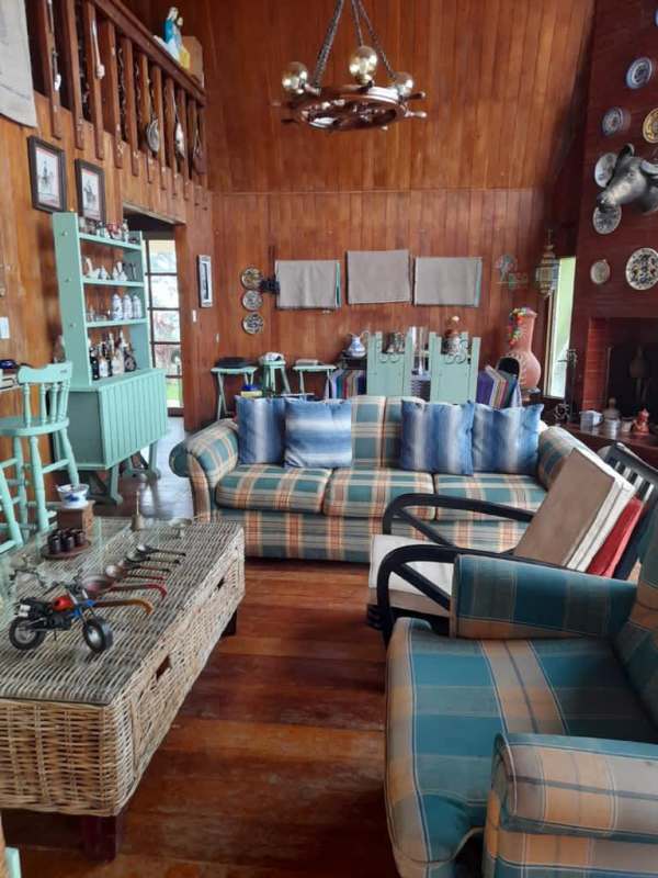 Rustic bedroom with wood walls, king bed, teal decor in Cerro Azul Panama mountain house