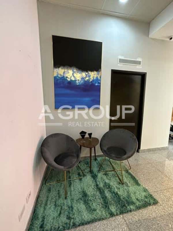 Partitioned wood desk with black chairs and wall art PH Habitats Plaza Calle 50