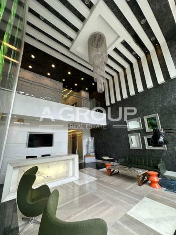Contemporary lounge with green sofas, chandelier, double height ceiling PH Habitats Plaza