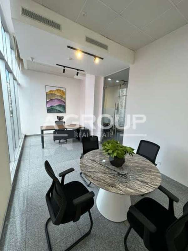 Office with large window overlooking city skyline, wooden desk PH Habitats Plaza