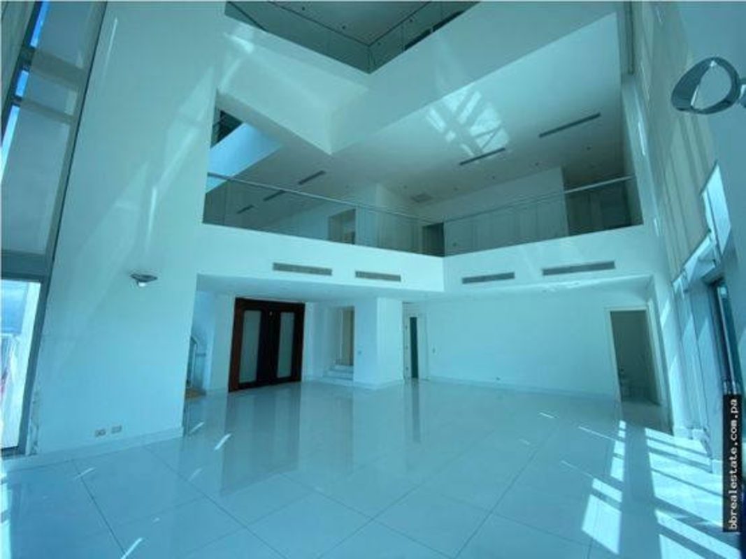 Double-height living room with floor-to-ceiling windows showing Pacific Ocean view in PH Ten Tower Costa del Este