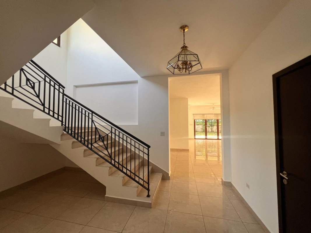 Open foyer with large windows, elegant staircase and chandelier at Senderos de Cruces Clayton