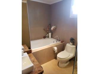 Contemporary bathroom with beige tiles, bathtub and sink at Eagles Landing Panama
