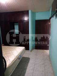 Traditional dining room with wooden table, tile floors, and large windows in Chitré house