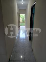 Traditional kitchen with wooden cabinets, tile counters, and gas stove in Chitré house