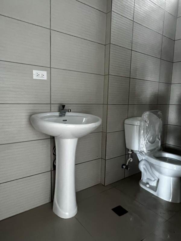 Minimalist bathroom with pedestal sink and tiled walls inside commercial unit at Plaza Level 37 Panama