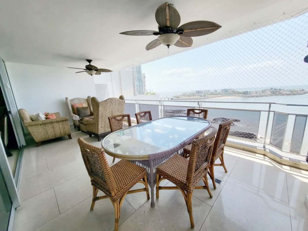 Large balcony with ocean view glass railing and outdoor seating Punta Paitilla Panama