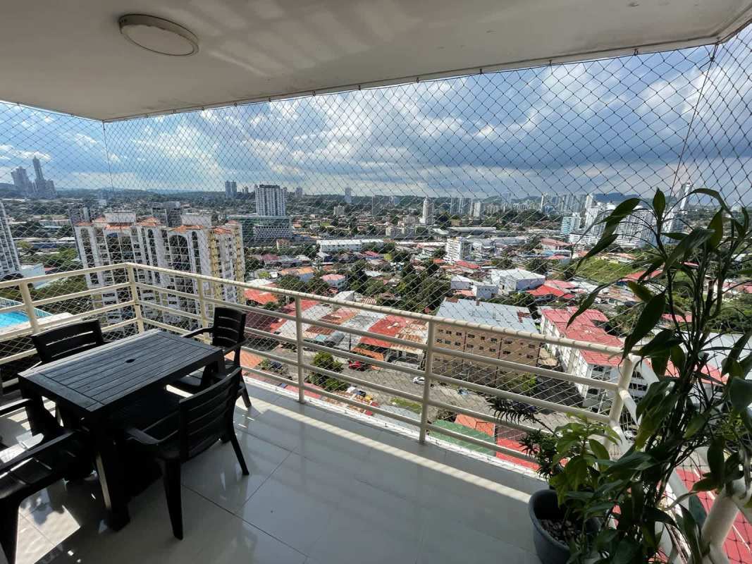Open living space with large windows and exposed brick wall in PH Sky Level Panama