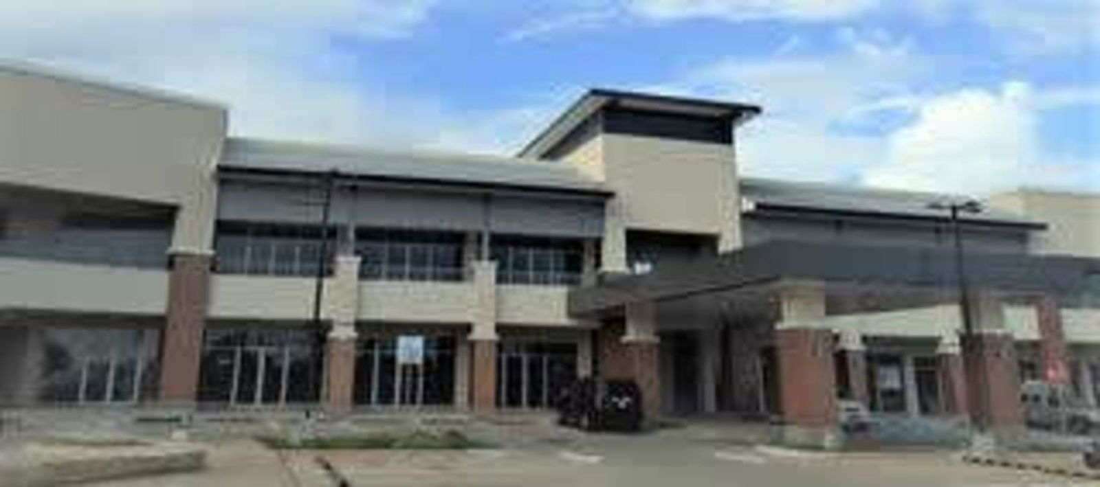 Facade of contemporary two-story commercial shopping plaza with covered entrance and large windows at Plaza Villalobos Panama City
