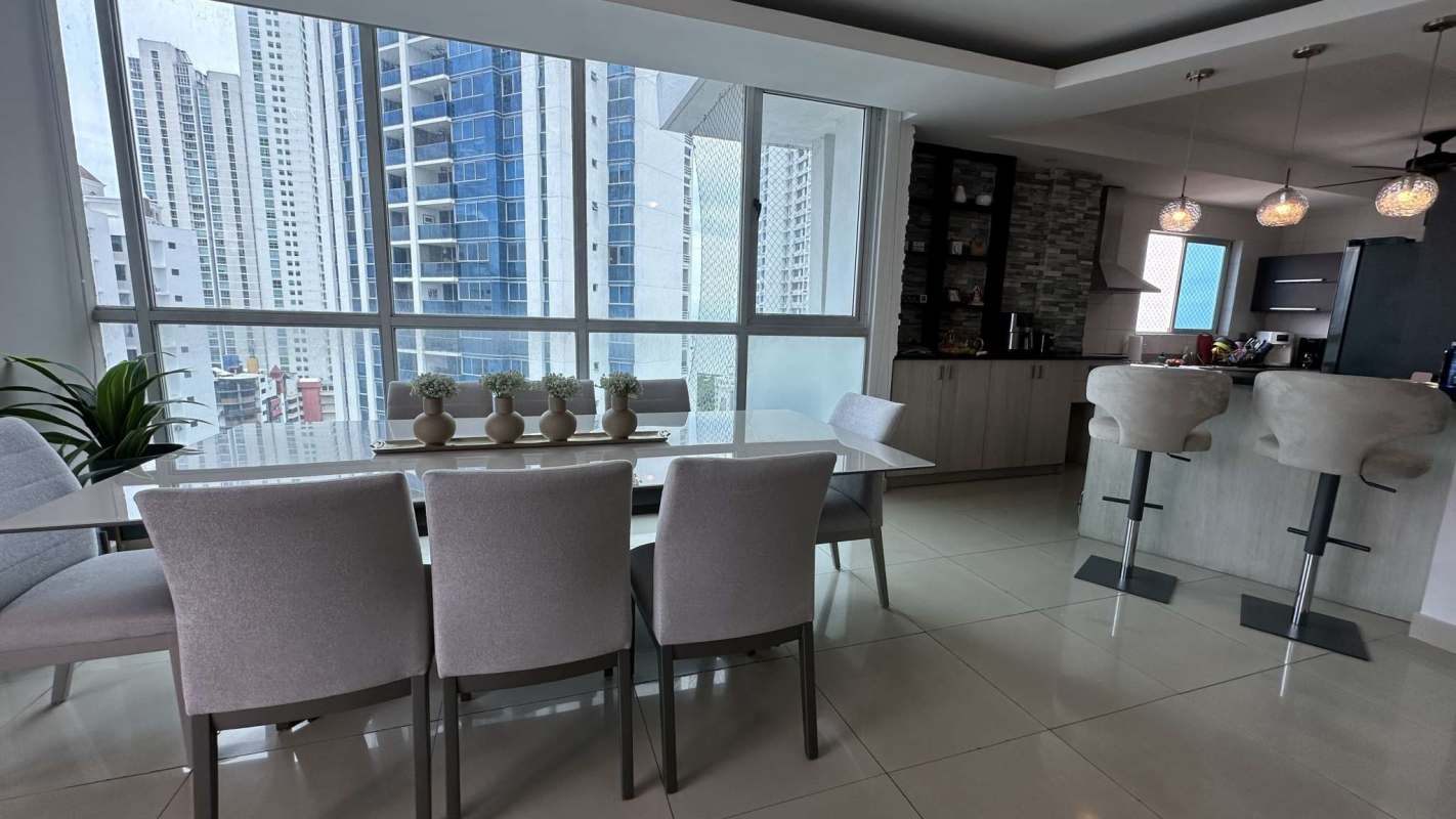 Modern dining area next to open kitchen with breakfast bar at PH Grecia San Francisco Panama