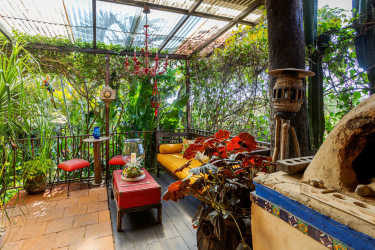 Colorful rustic patio area with pergola and lush greenery at Boquete hotel cabins