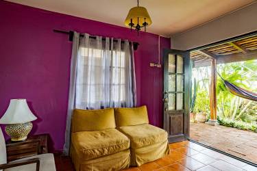 Cozy colorful living area with garden view and patio door in Boquete guest cabin hotel for sale