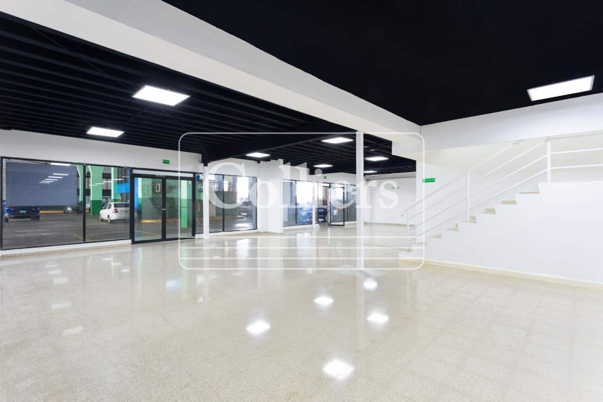 Open floor plan commercial showroom with glass windows and staircase at Plaza Ágora Chanis