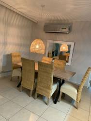Dining room with wicker chairs, wood table and tropical decor Bijao Beach Panama