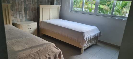 Main bedroom with large window, queen bed and tropical garden views PH Bijao Panama