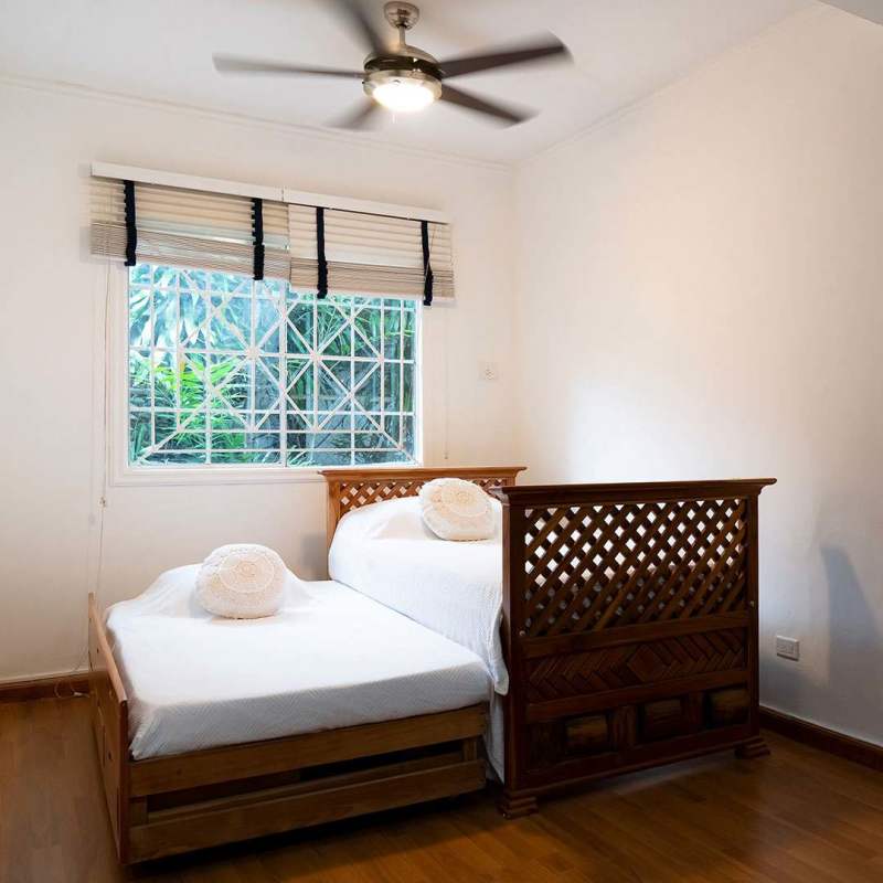 Bedroom or office with daybed, large window with security bars, ceiling fan, wood floor in Obarrio Panama commercial property